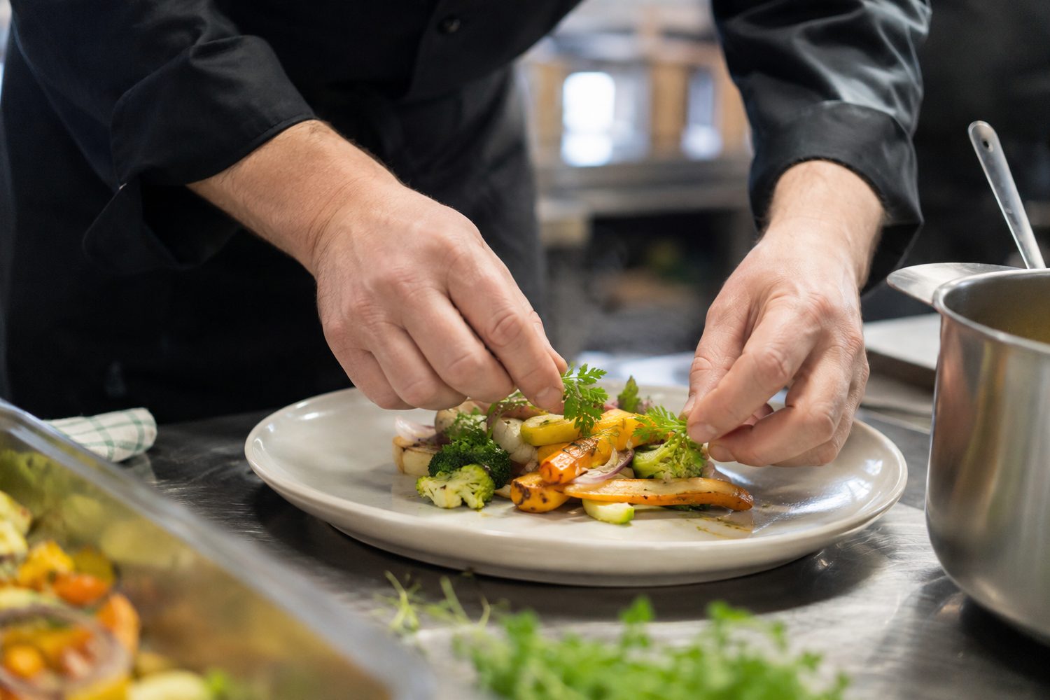 Dressage d'assiettes sur un plan de travail en inox, en cuisine professionnelle